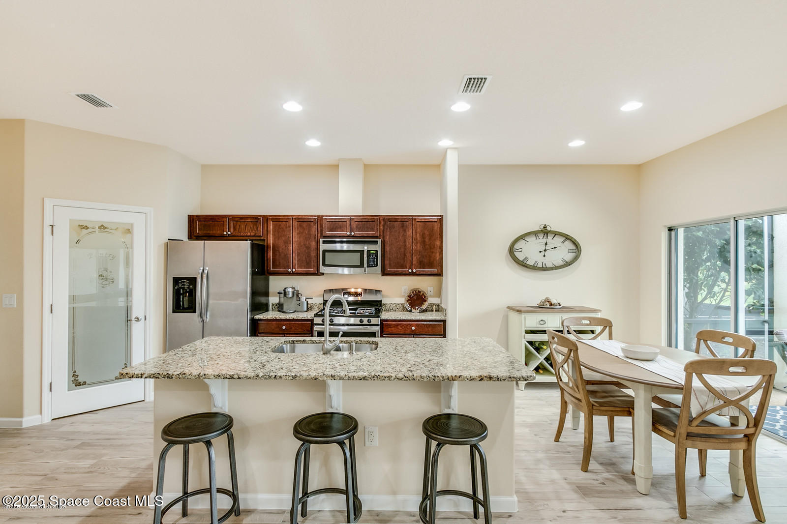 3180 Constellation Drive Melbourne, FL 32940 - Photo 5 of 18 a dining hall with stainless steel appliances kitchen island granite countertop a dining table chairs and couches