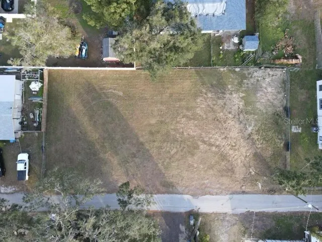 an aerial view of a house with a yard and lake view