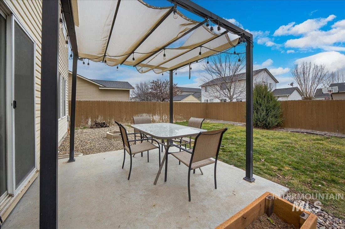 5106 Lathrop Place, Unit 19517 Caldwell, ID 83607 - Photo 10 of 29 Fenced backyard with a patio area, outdoor dining space, and a pergola