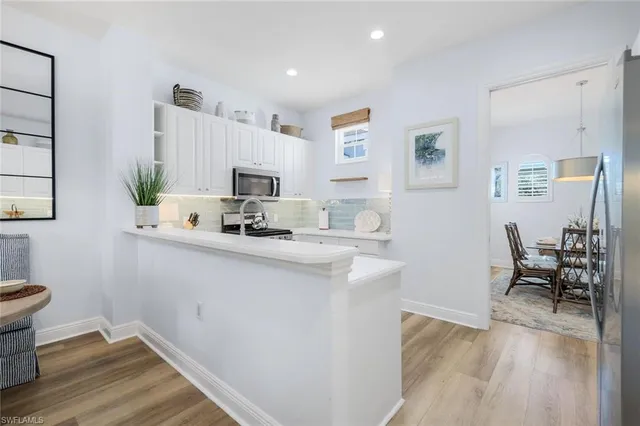 a living room with furniture flat screen tv and windows