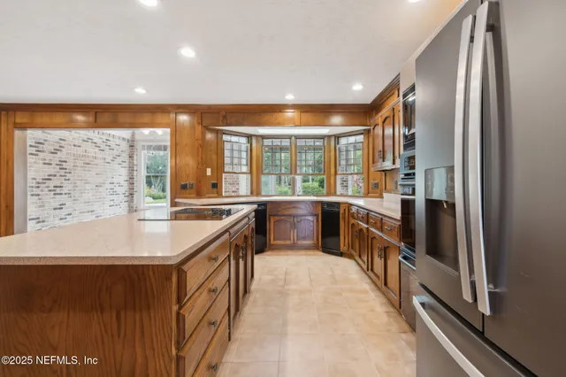 a view of an empty room with a chandelier fan