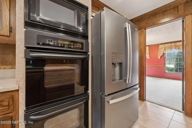 a view of an empty room with chandelier fan and fire place