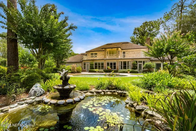 a view of a garden with a house in the background