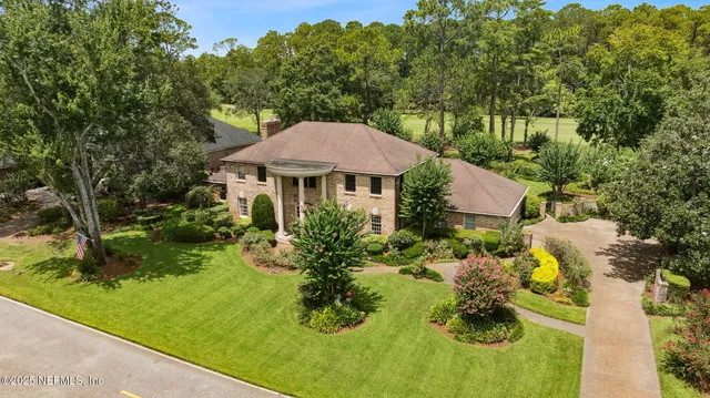 an aerial view of residential houses with outdoor space and trees