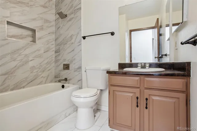 a bathroom with a granite countertop sink toilet and shower