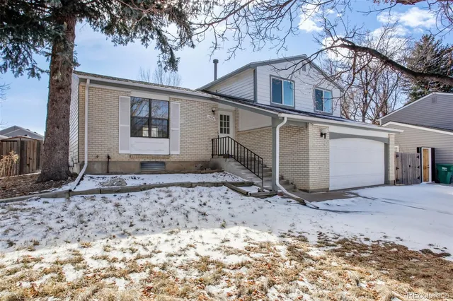 a view of a white house with a large tree
