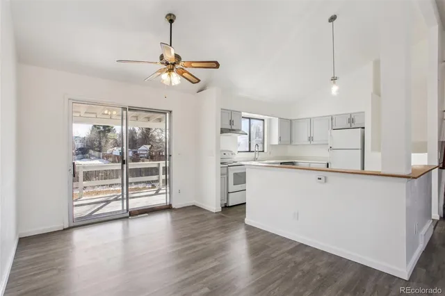 a open kitchen with white cabinets and wooden floor