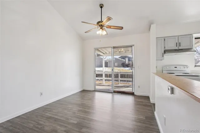 a view of a kitchen with wooden floor and a ceiling fan