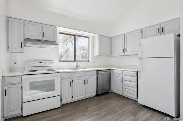 a kitchen with cabinets appliances a sink and a window