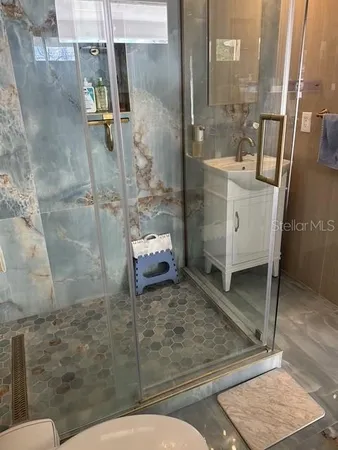 a bathroom with a granite countertop sink mirror and toilet