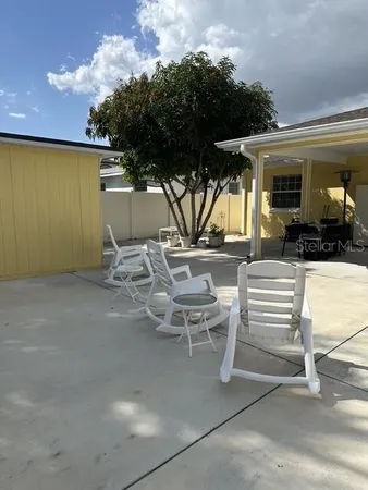 a view of a patio with a table and chairs under an umbrella with a fireplace