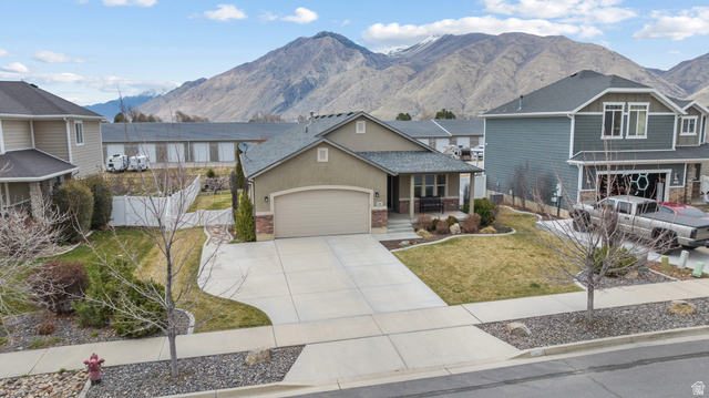 1896 West 800 North Mapleton, UT 84663 - Photo 2 of 55 View of front of home featuring a mountain view, concrete driveway, covered porch, a garage, and brick siding