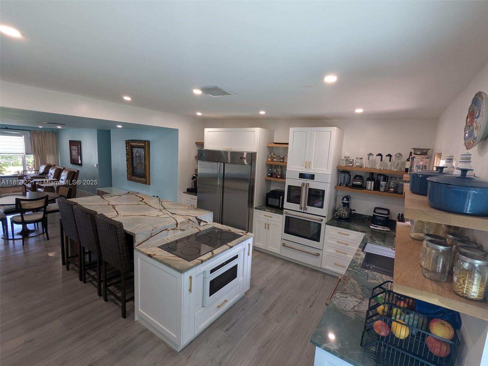 a kitchen with stainless steel appliances kitchen island granite countertop a stove and a refrigerator