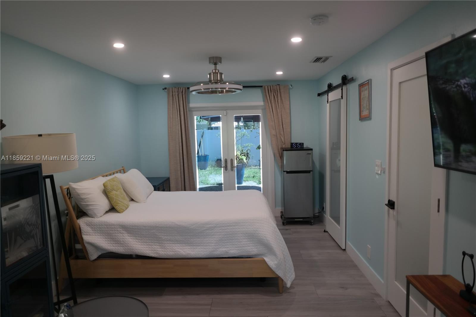 524 Northeast 27th Drive Wilton Manors, FL 33334 - Photo 17 of 95 a bedroom with a bed window and a television