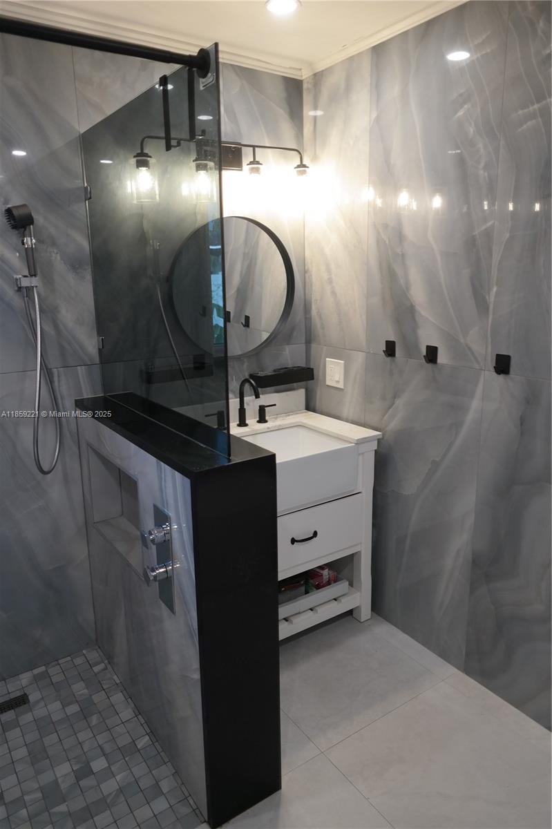 524 Northeast 27th Drive Wilton Manors, FL 33334 - Photo 20 of 95 Expansive shared bathroom featuring a spa-style walk-in shower, two separate deep sink vanities, and dual smart toilets.