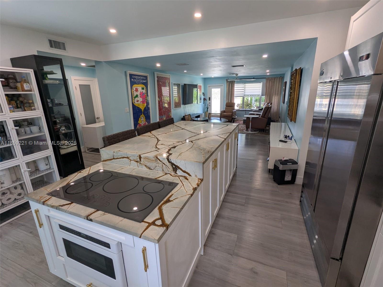 524 Northeast 27th Drive Wilton Manors, FL 33334 - Photo 2 of 95 Gorgeous showstopper island with quartz countertop and sleek lower-level electric range and plenty of storage in a modern kitchen design.