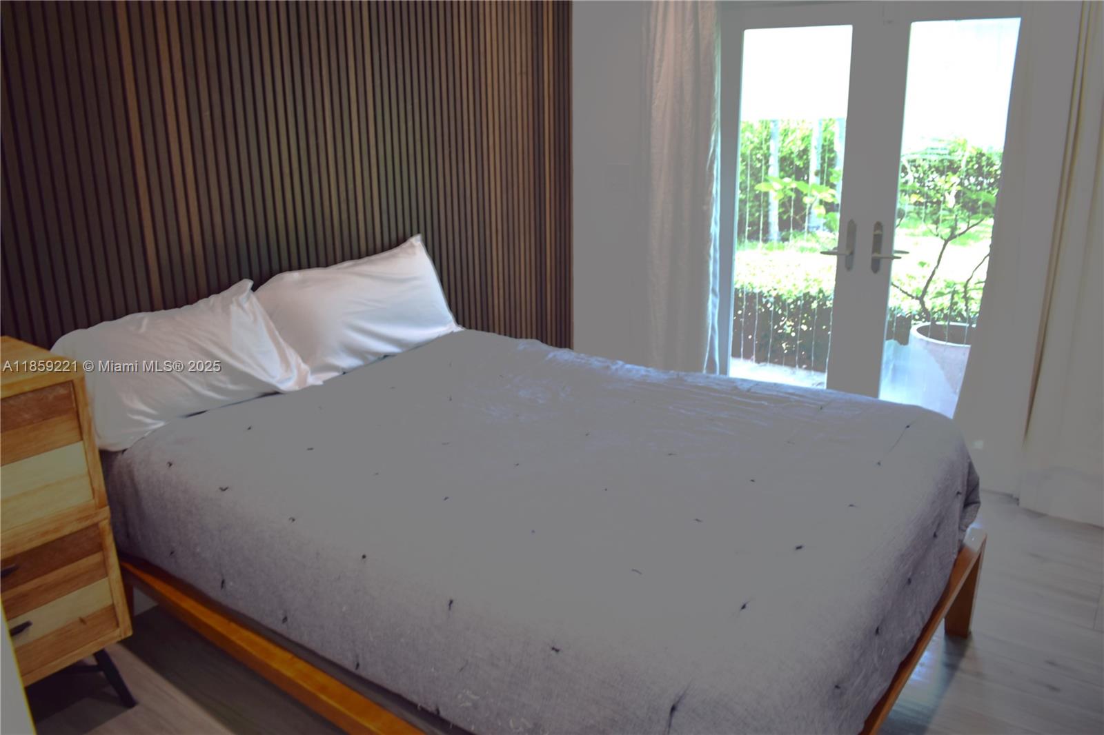 524 Northeast 27th Drive Wilton Manors, FL 33334 - Photo 22 of 95 a bed sitting in a bedroom next to a window