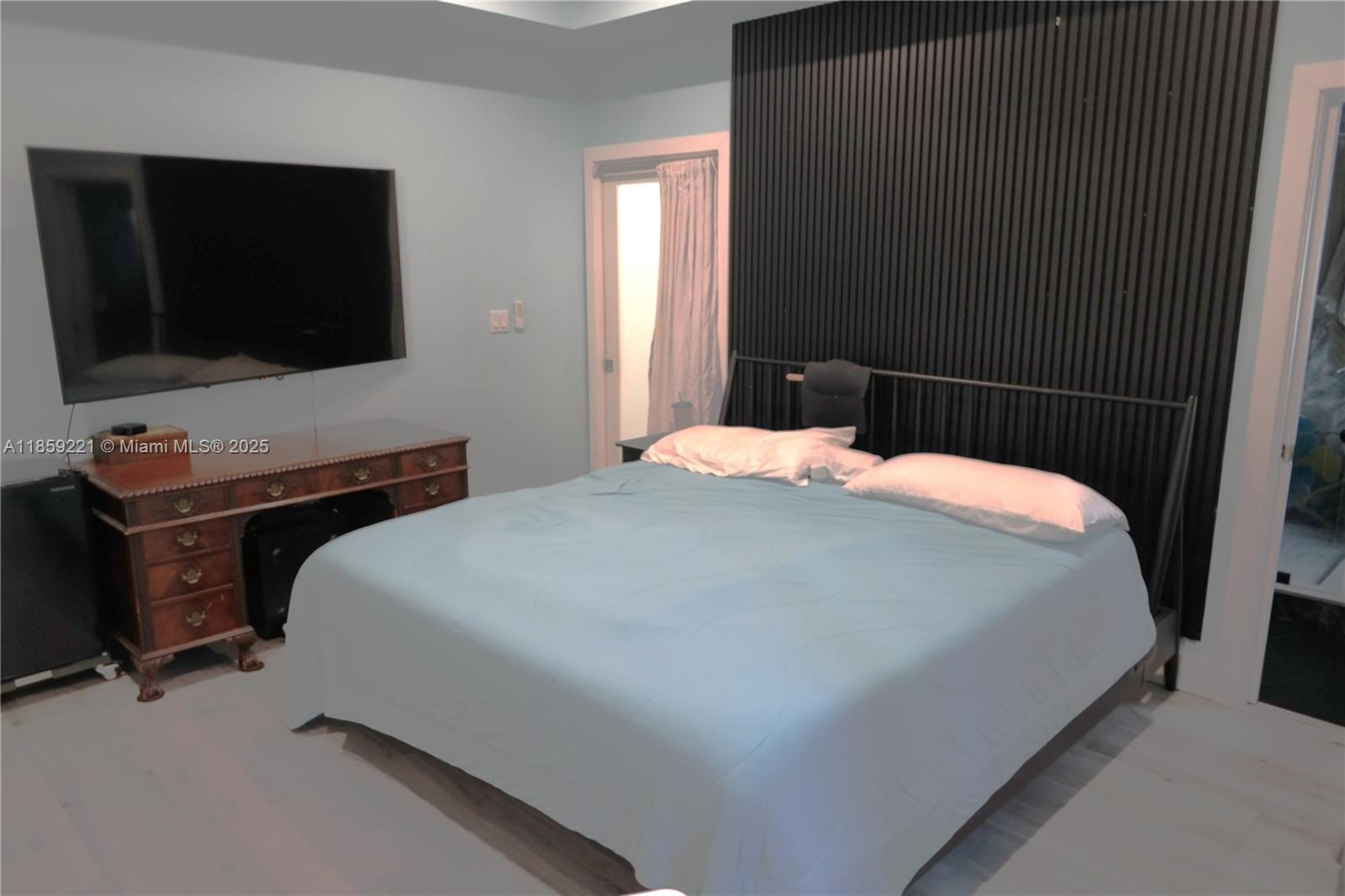 524 Northeast 27th Drive Wilton Manors, FL 33334 - Photo 23 of 95 a bedroom with a bed and a flat screen tv