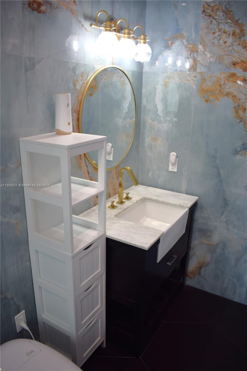 524 Northeast 27th Drive Wilton Manors, FL 33334 - Photo 30 of 95 Beautiful private bathroom showcasing vibrant blue and golden tiles carefully crafted for a seamless luxurious design, and deep sink with front exposure to enhance your daily routines.