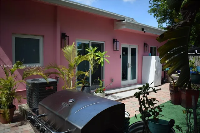 a view of a house with a small yard and palm trees