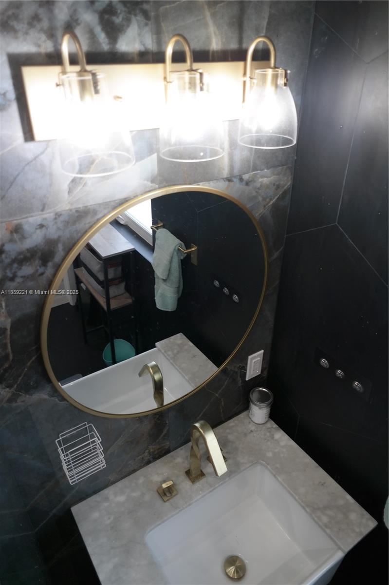 524 Northeast 27th Drive Wilton Manors, FL 33334 - Photo 74 of 95 Contemporary bathrooms include upgraded deep sinks with elegant golden faucets and fixtures for modern and chic aesthetic.