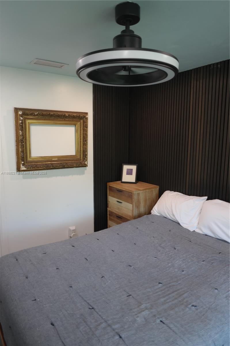 524 Northeast 27th Drive Wilton Manors, FL 33334 - Photo 78 of 95 a bedroom with a bed and a chandelier