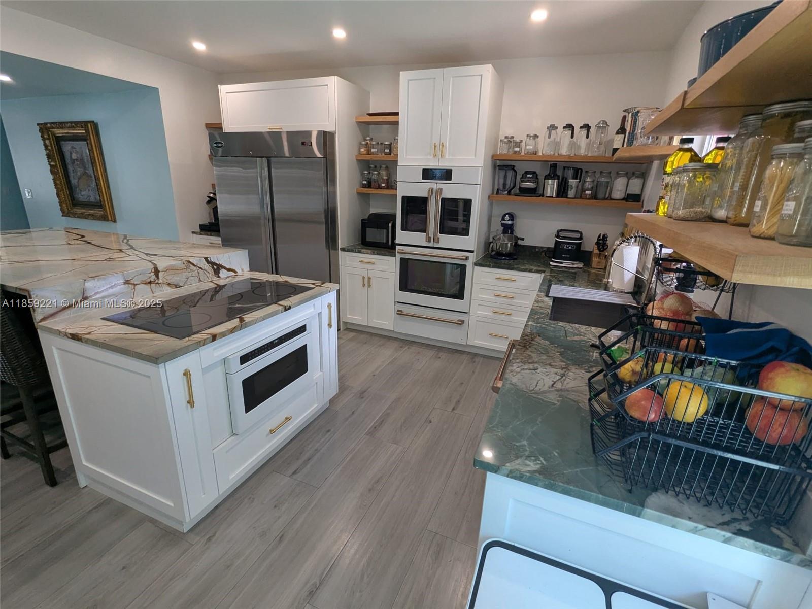 524 Northeast 27th Drive Wilton Manors, FL 33334 - Photo 92 of 95 a kitchen with stainless steel appliances granite countertop a stove a sink and a refrigerator