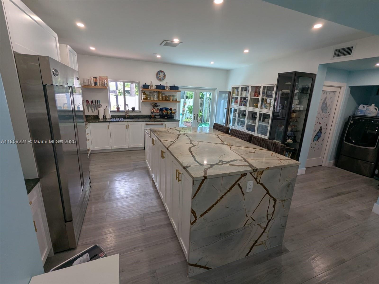 524 Northeast 27th Drive Wilton Manors, FL 33334 - Photo 10 of 95 Expansive quartz waterfall island with plenty cabinetry and ample breakfast bar seating for everyday comfort.