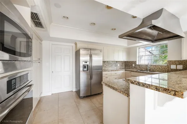 a kitchen with stainless steel appliances granite countertop a sink and a refrigerator