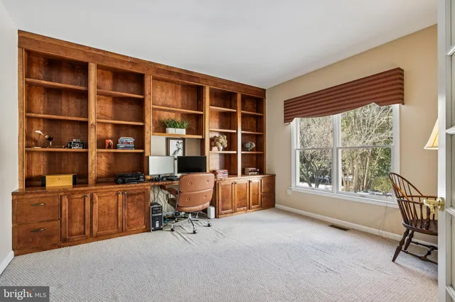 a view of a workspace with furniture and a window