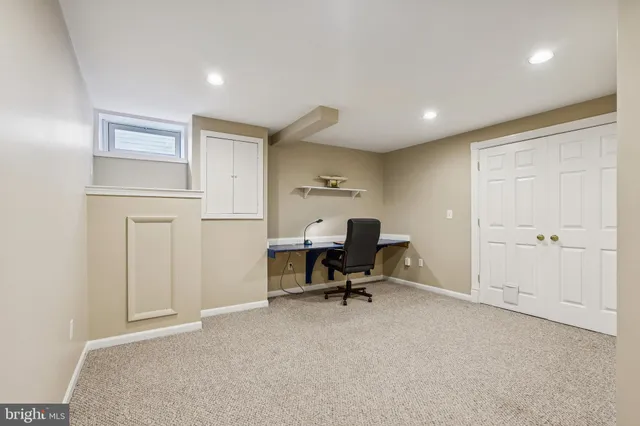 a view of a workspace with furniture and a window