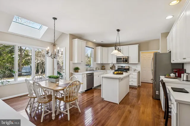 a kitchen with refrigerator a stove and chairs