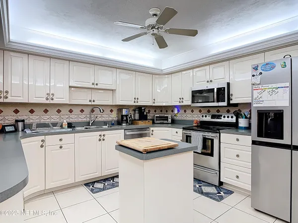 a kitchen with a dining table chairs cabinets and stainless steel appliances