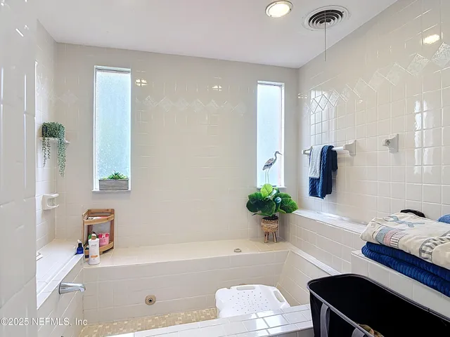 a bathroom with a tub a sink and a mirror