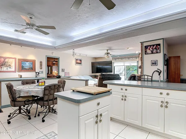 a living room with furniture and a view of kitchen