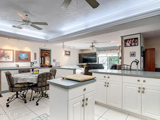 a living room with furniture and a view of kitchen