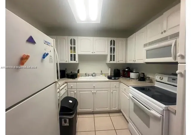 a kitchen with a white cabinets and white appliances