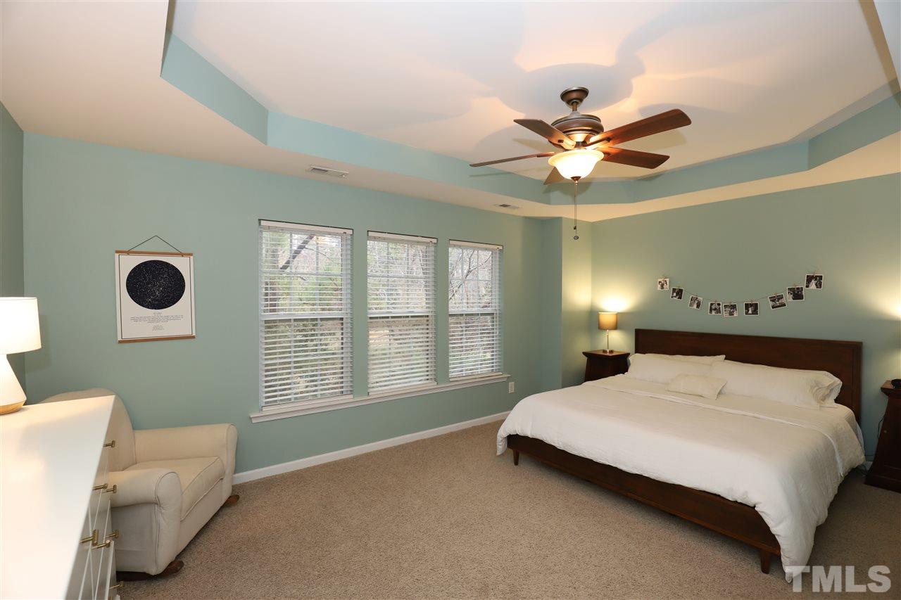 8610 Redcrest Place Raleigh, NC 27617 - Photo 12 of 30 a bedroom with a bed next to a window with a chandelier