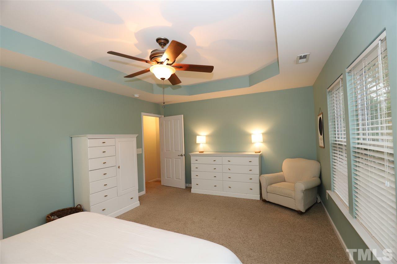 8610 Redcrest Place Raleigh, NC 27617 - Photo 13 of 30 a bedroom with a bed and a ceiling fan