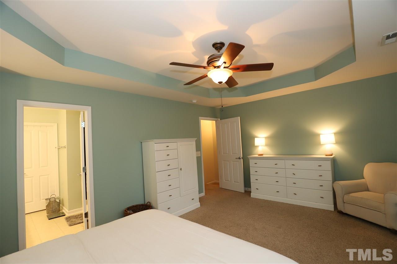 8610 Redcrest Place Raleigh, NC 27617 - Photo 14 of 30 a spacious bedroom with a bed and a chandelier