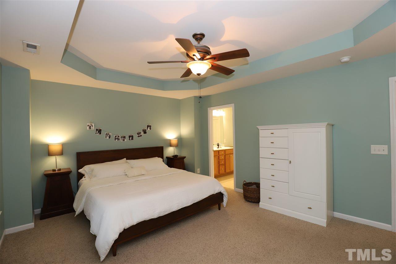 8610 Redcrest Place Raleigh, NC 27617 - Photo 15 of 30 a bedroom with a bed and a ceiling fan
