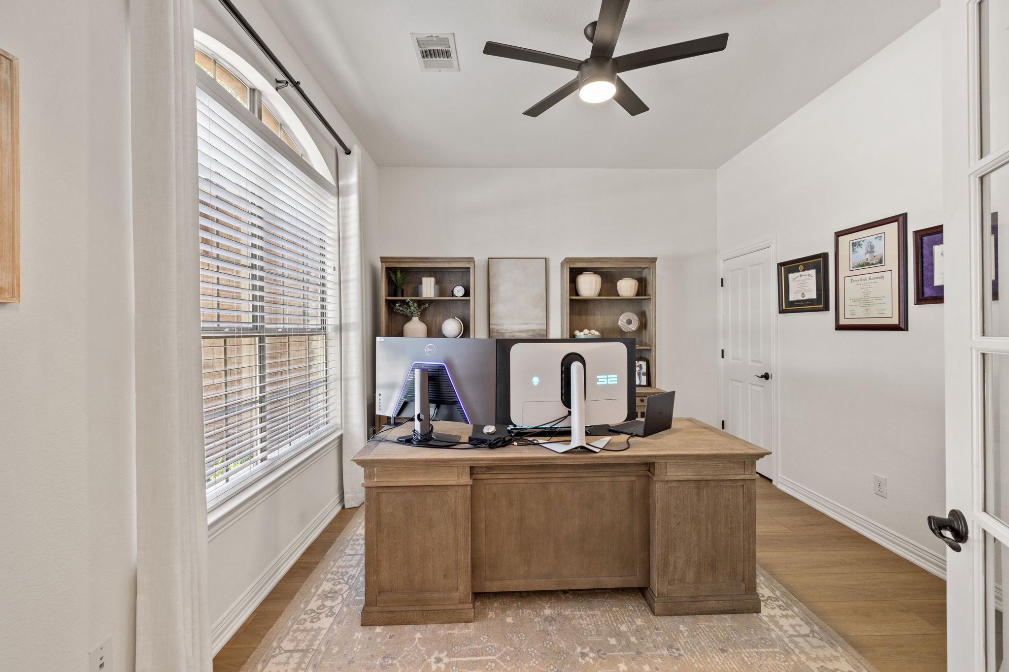 1124 Castle Path Round Rock, TX 78681 - Photo 4 of 40 A dedicated home office provides a quiet space for productivity, featuring a substantial desk, warm wood flooring, and ample natural light.