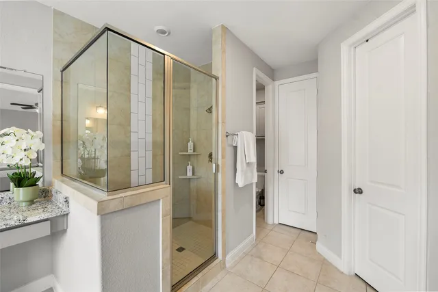 a bathroom with a glass shower door and a mirror