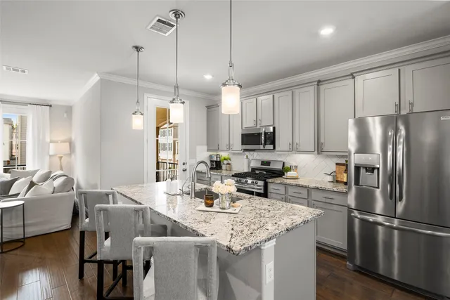 a kitchen with stainless steel appliances granite countertop a kitchen island hardwood floor and a sink