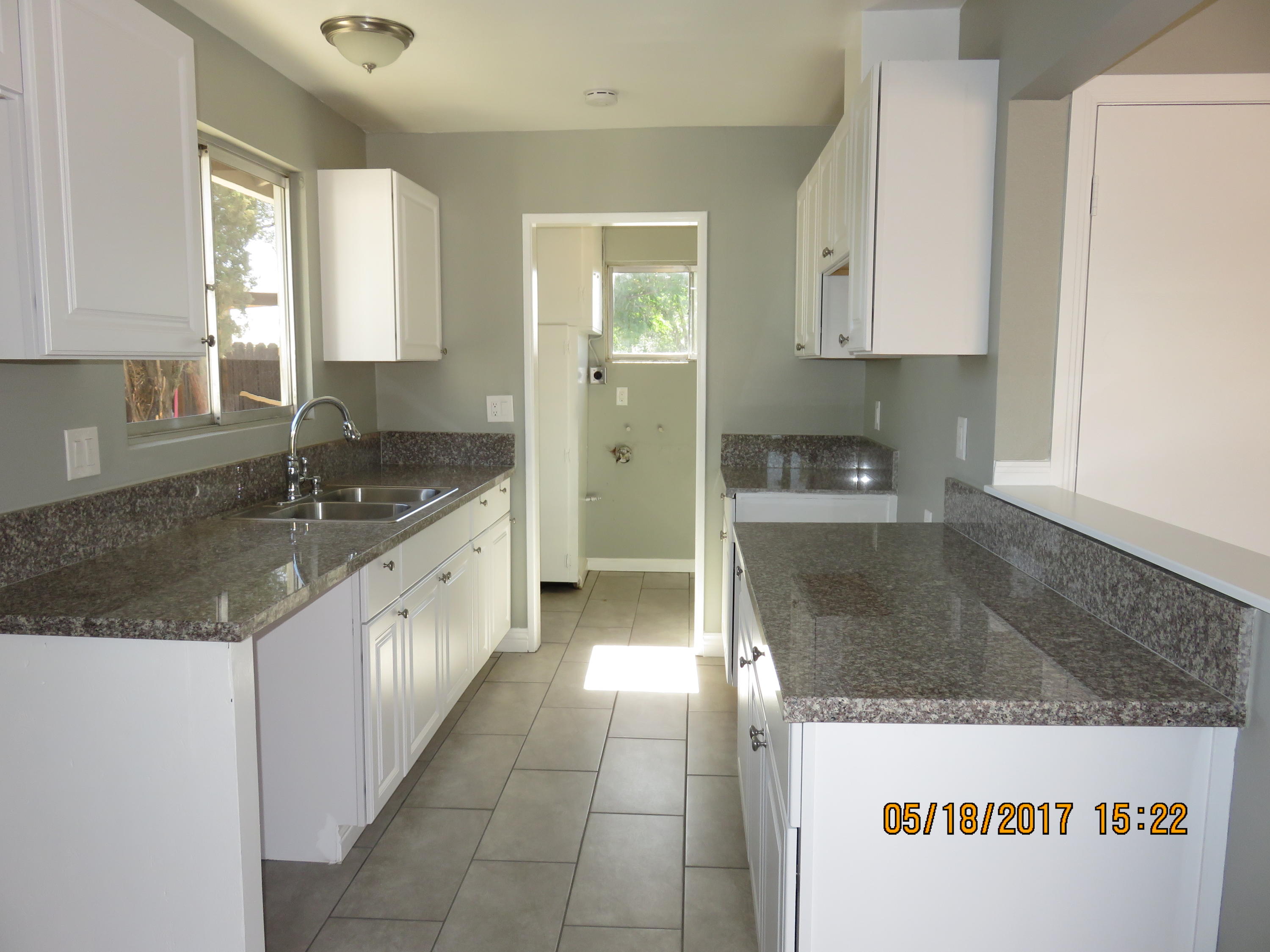 45402 Raysack Avenue Lancaster, CA 93535 - Photo 3 of 15 a large kitchen with granite countertop a sink and cabinets