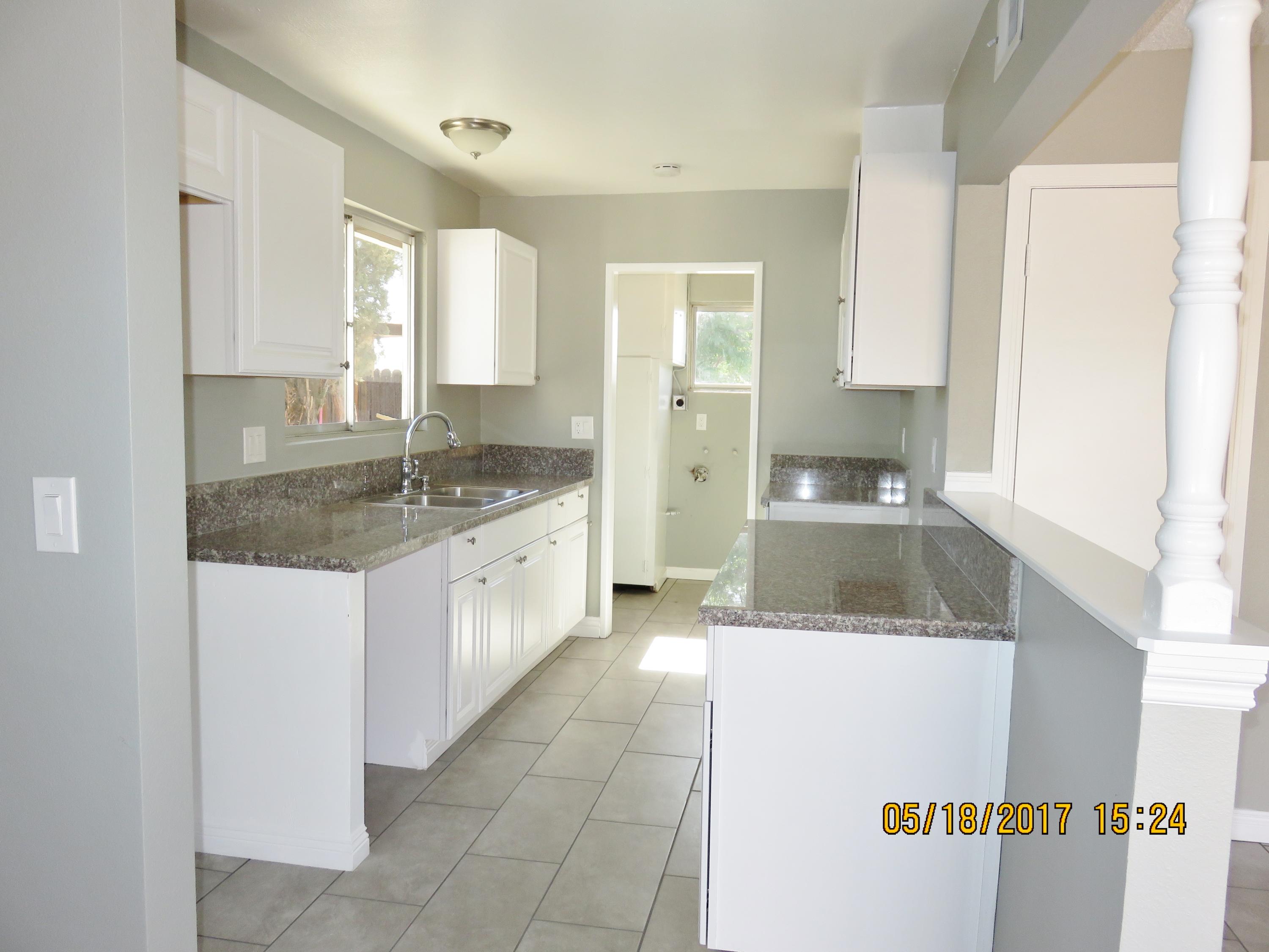 45402 Raysack Avenue Lancaster, CA 93535 - Photo 5 of 15 a large white kitchen with a sink and cabinets