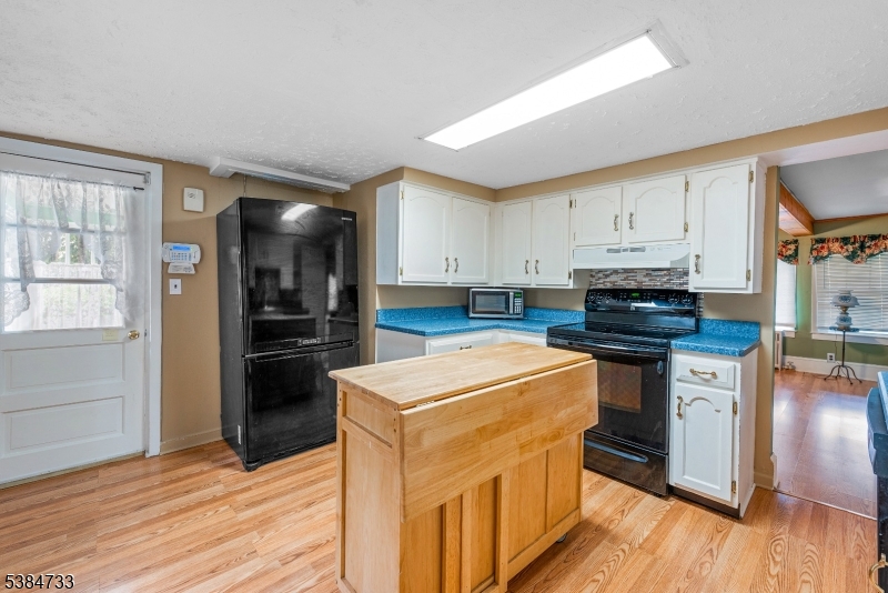 400 Quaker Church Road Randolph, NJ 07869 - Photo 19 of 34 a kitchen with stainless steel appliances white cabinets and wooden floor