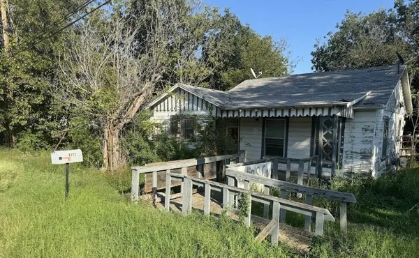 a backyard of a house with table and chairs