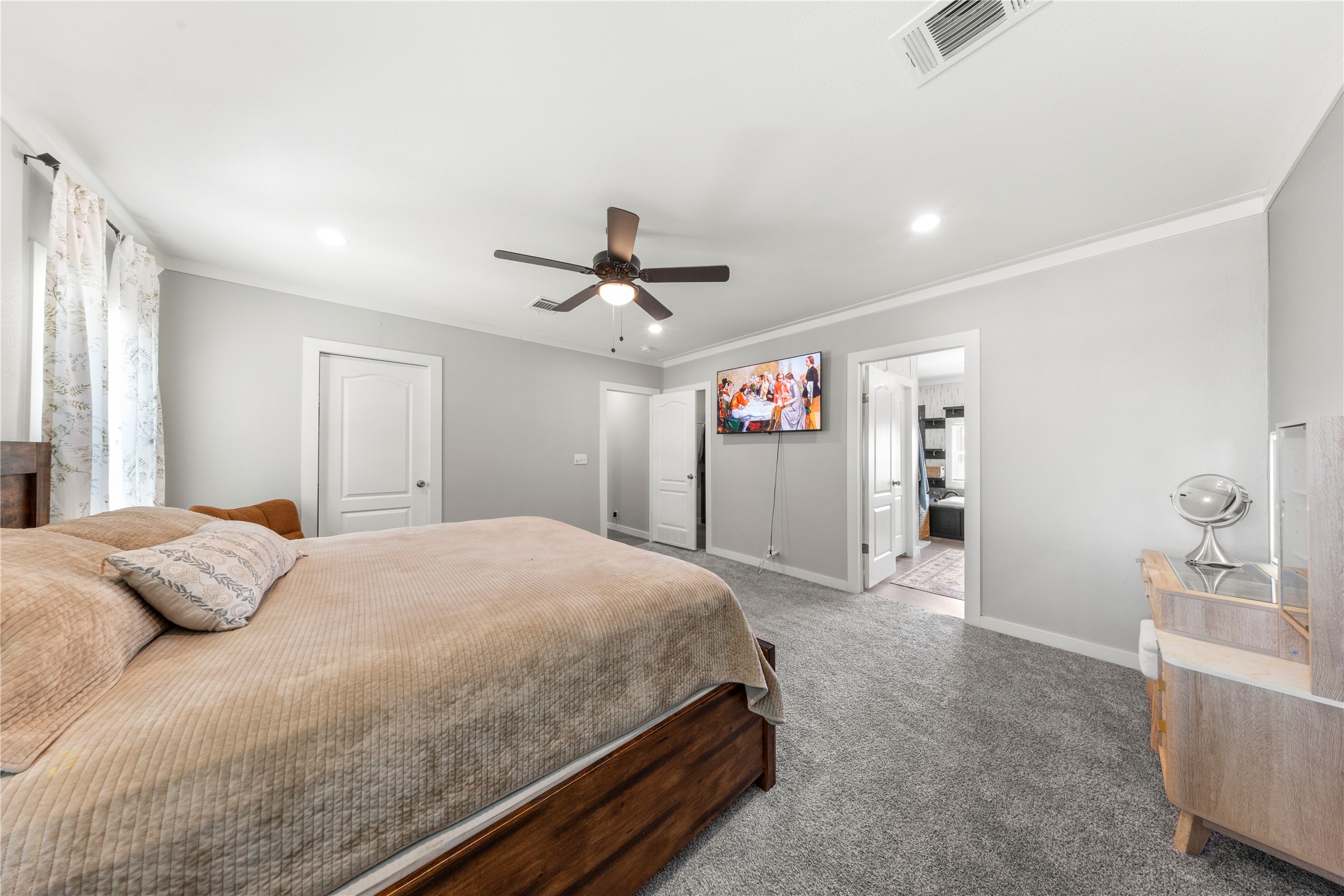 201 Greenfield Road Kyle, TX 78640 - Photo 14 of 28 Comfortable bedroom with soft carpet, bright recessed lighting, and a refreshing ceiling fan for optimal relaxation.