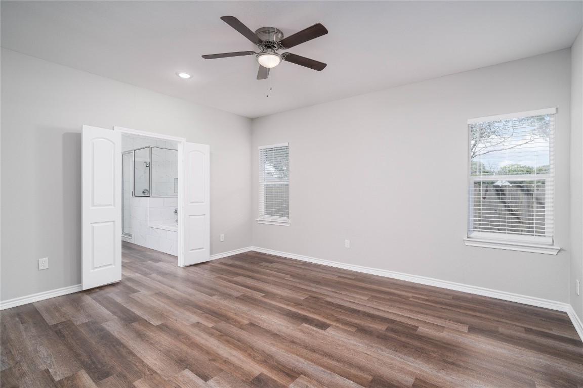 231 McCormick Street Columbus, TX 78934 - Photo 11 of 27 Primary Bedroom – Expansive primary suite featuring multiple windows, ceiling fan, and plenty of room for a full furniture set.